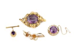 A collection of gem set brooches, comprising a Victorian amethyst single stone panel brooch, the