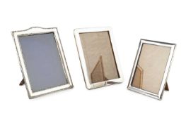 An Edwardian silver rectangular photograph frame, with arched top and embossed decoration, by