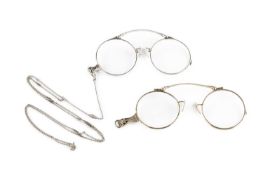 Two pairs of lorgnettes, decorated with foliate borders, each white metal mounted and stamped '14K',