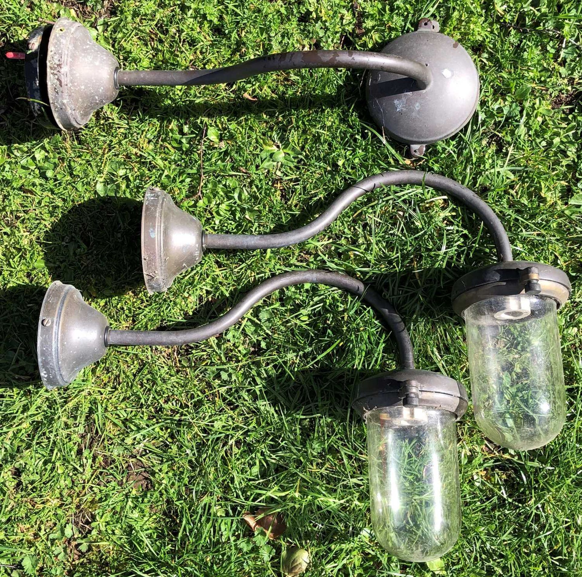 A set of three brass external wall lights