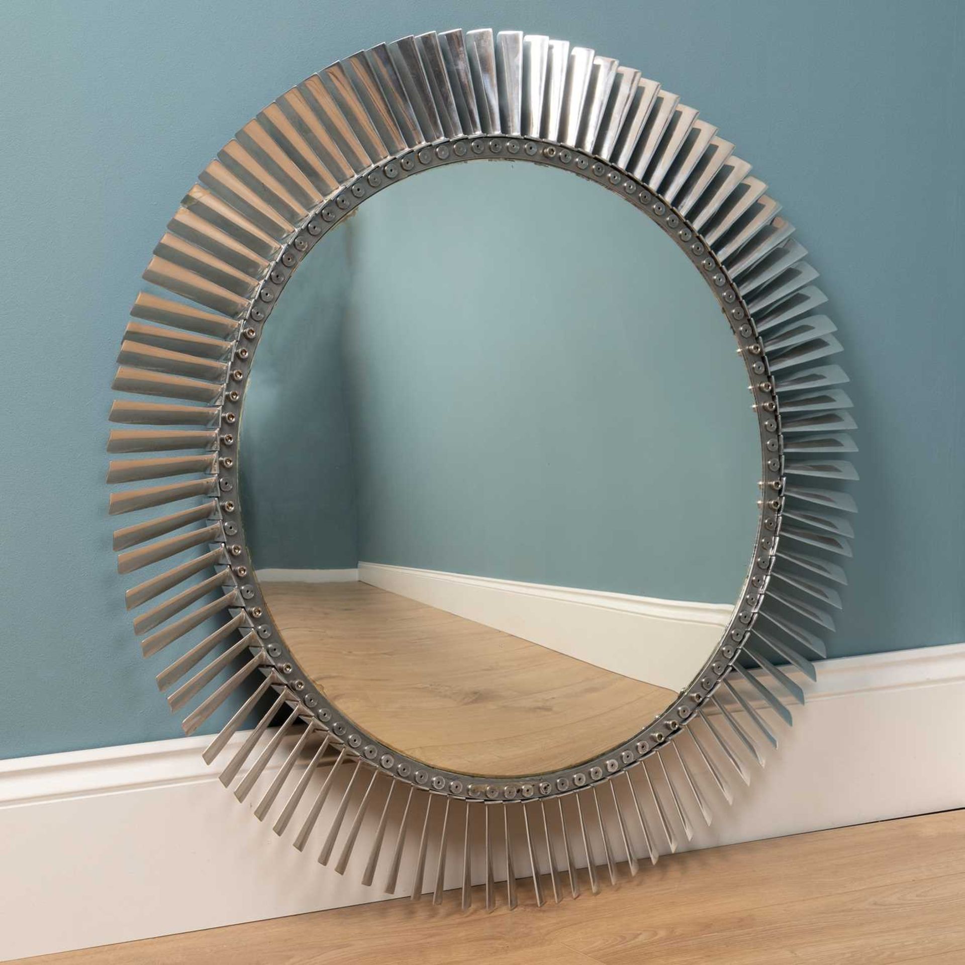 A convex chrome turbine style wall mirror