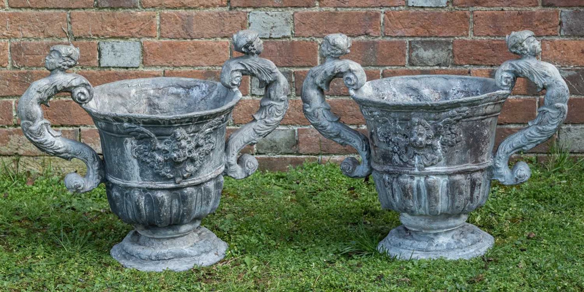 A pair of antique lead urns