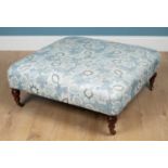 A blue florally upholstered footstool