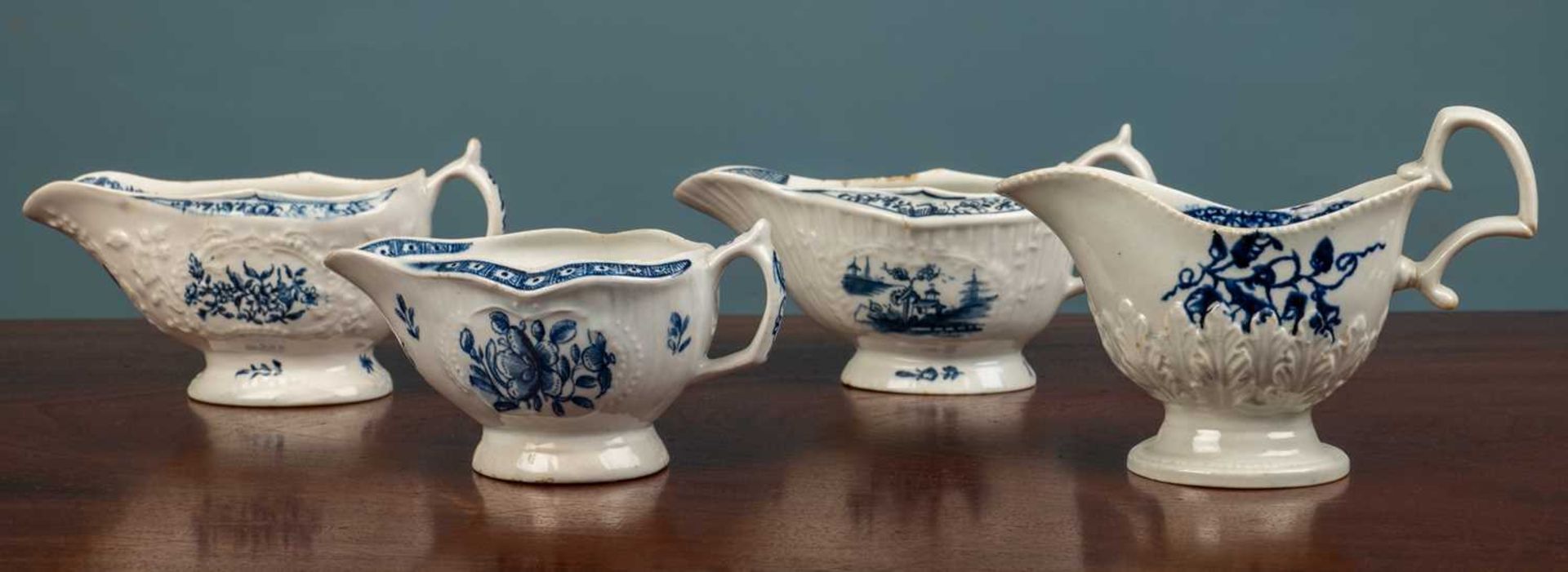 A group of four various blue and white sauceboats