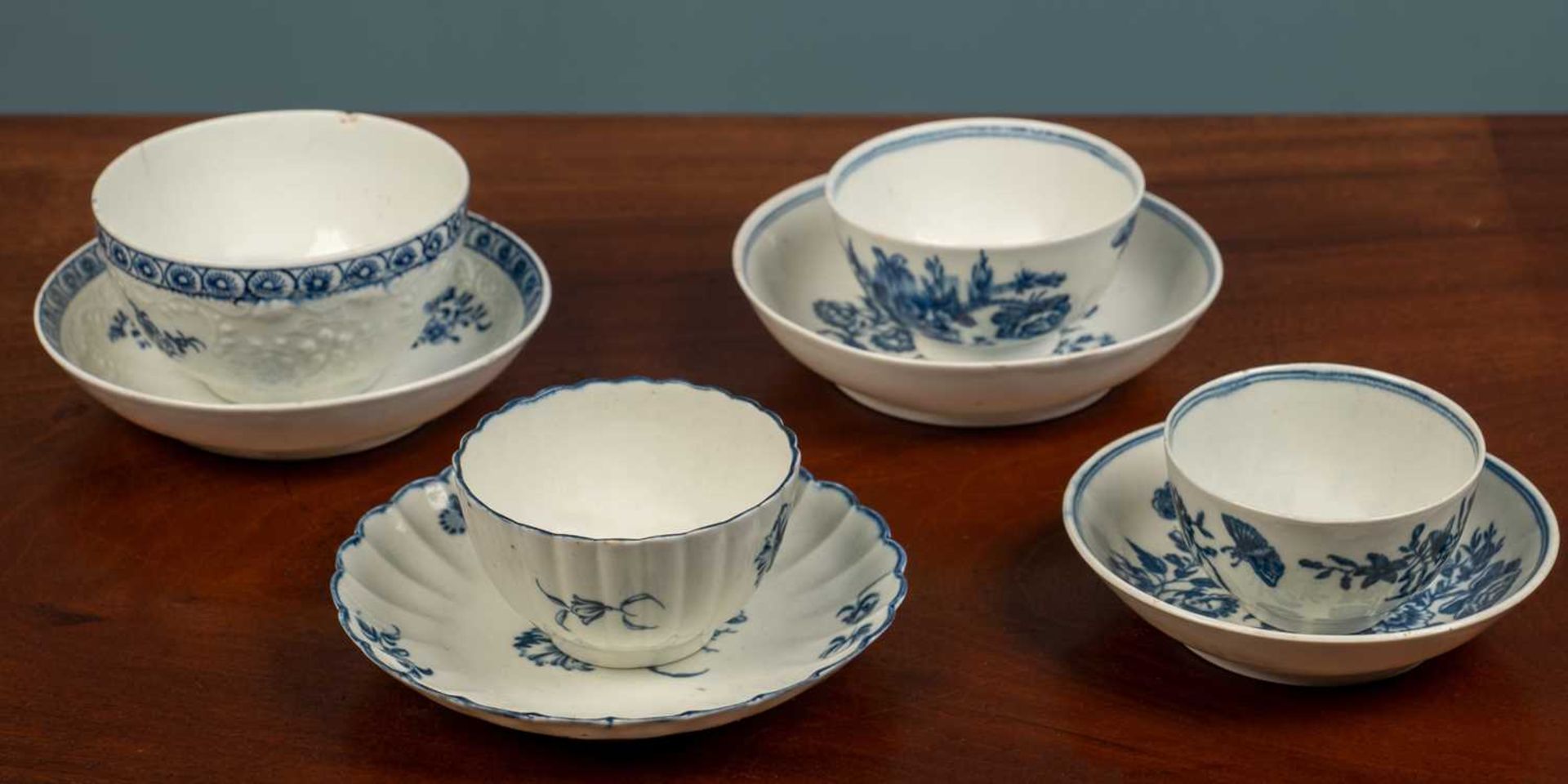 Two 18th century Worcester blue and white 'three flower' patterned tea bowls and saucers