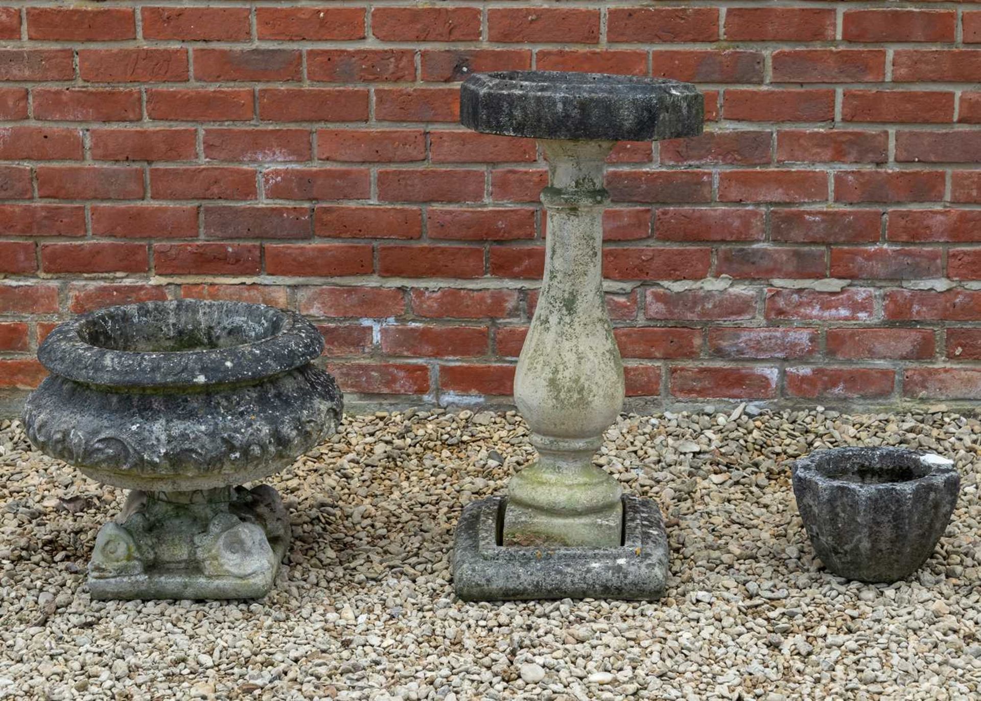 A cast reconstituted stone urn, a bird bath and a small planter