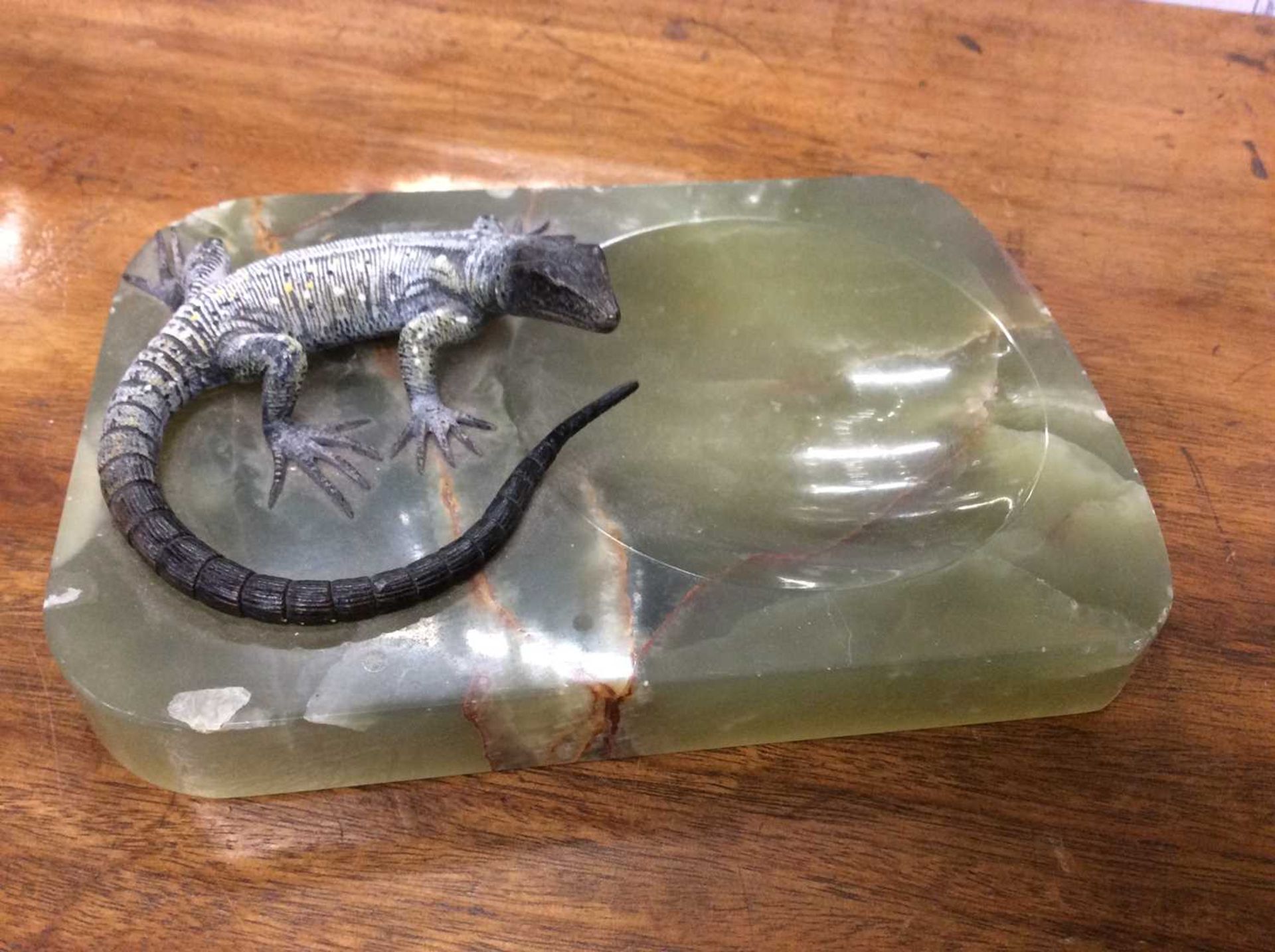 An onyx dish mounted with a cold painted bronze sculpture of a lizard