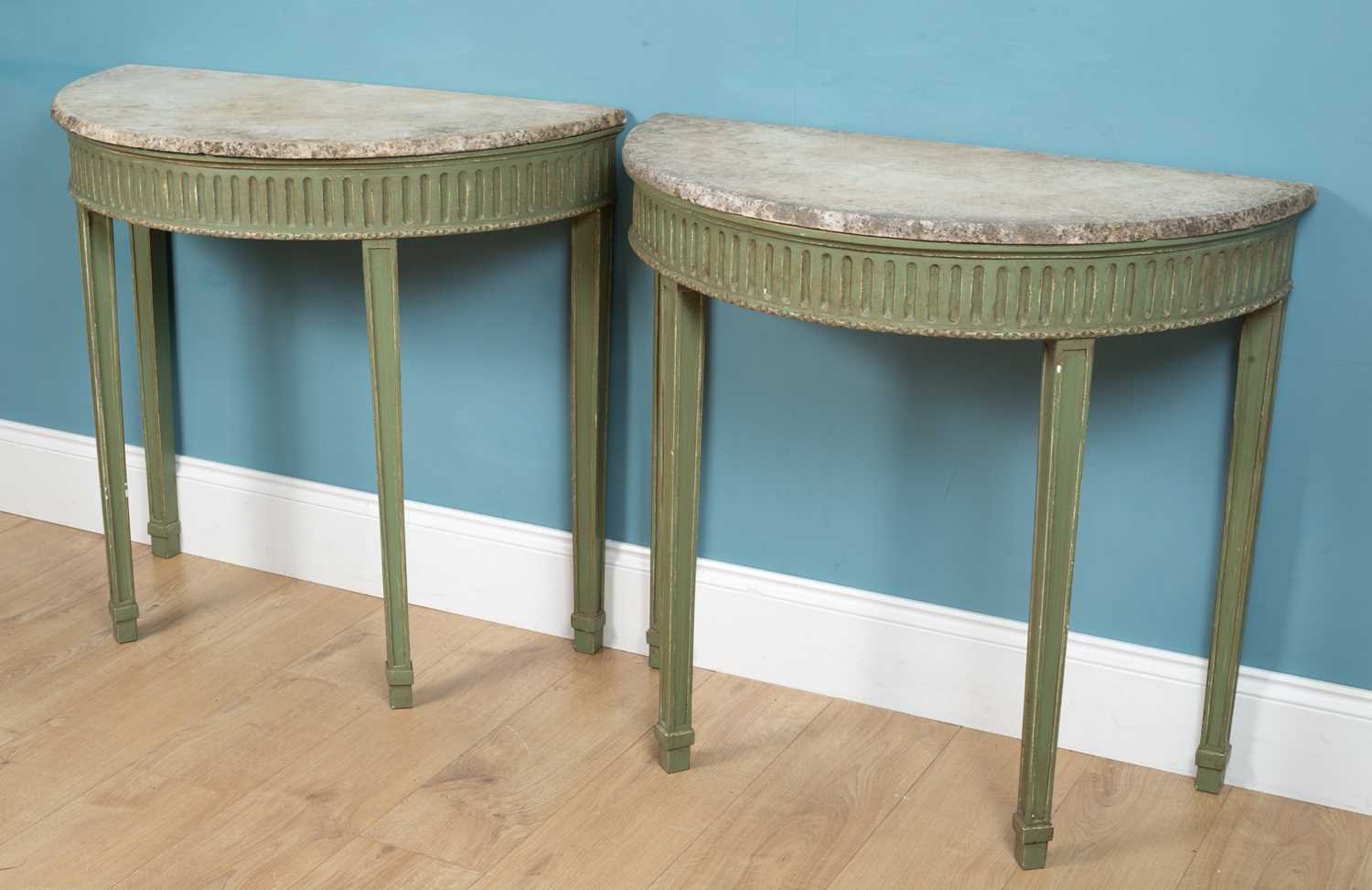 A pair of green-painted, marble-topped D-shaped console tables