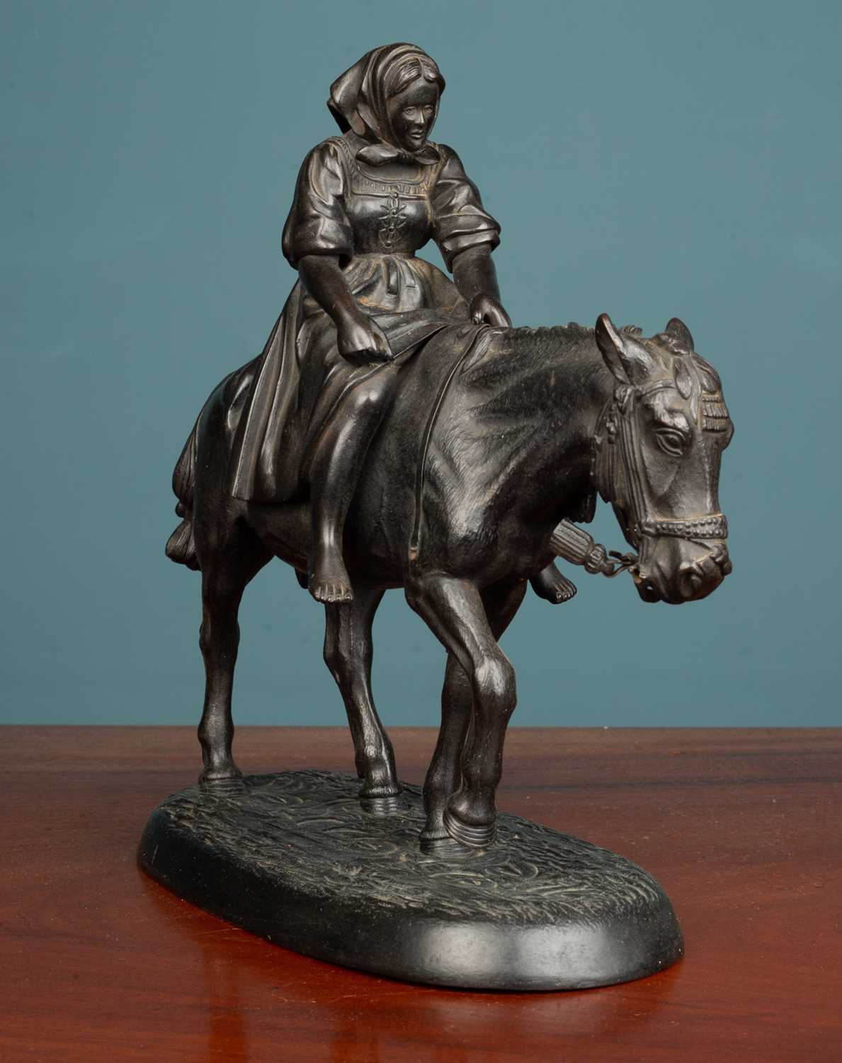 A Russian cast iron sculpture of a figure on the back of a mule