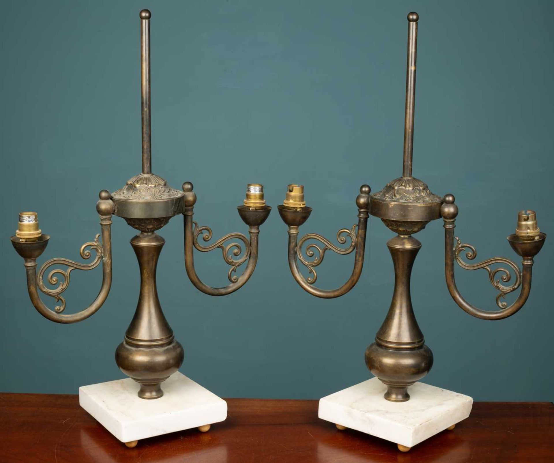 A pair of French empire style brass two branch candelabra lamps