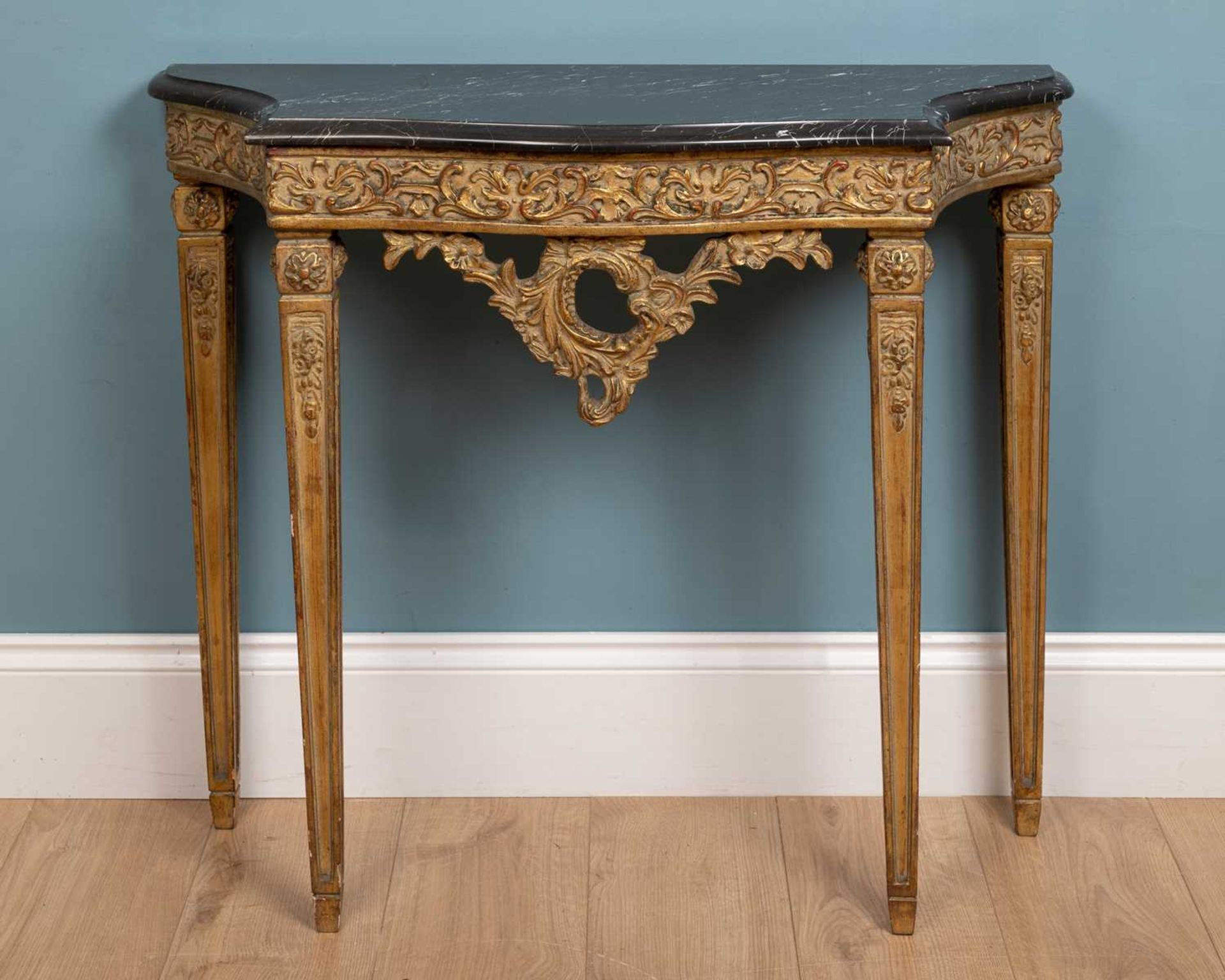 An 18th century French style ornately carved and painted giltwood console table