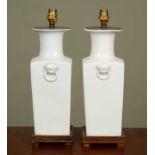 A pair of white glazed ceramic lamp stands