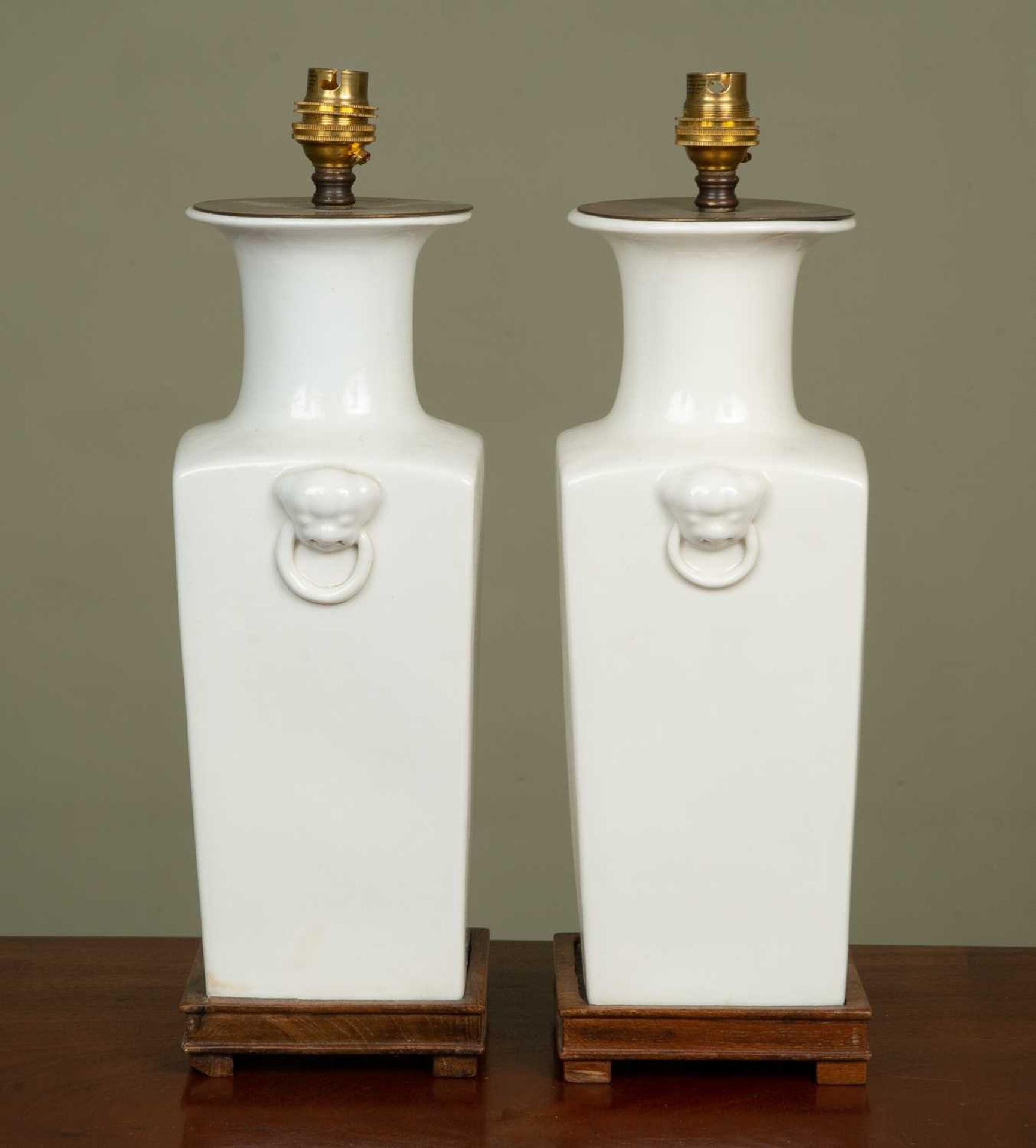 A pair of white glazed ceramic lamp stands