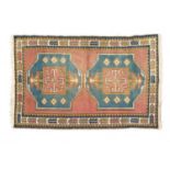 A mid to late 20th century Turkish cream, red and blue ground woolen rug