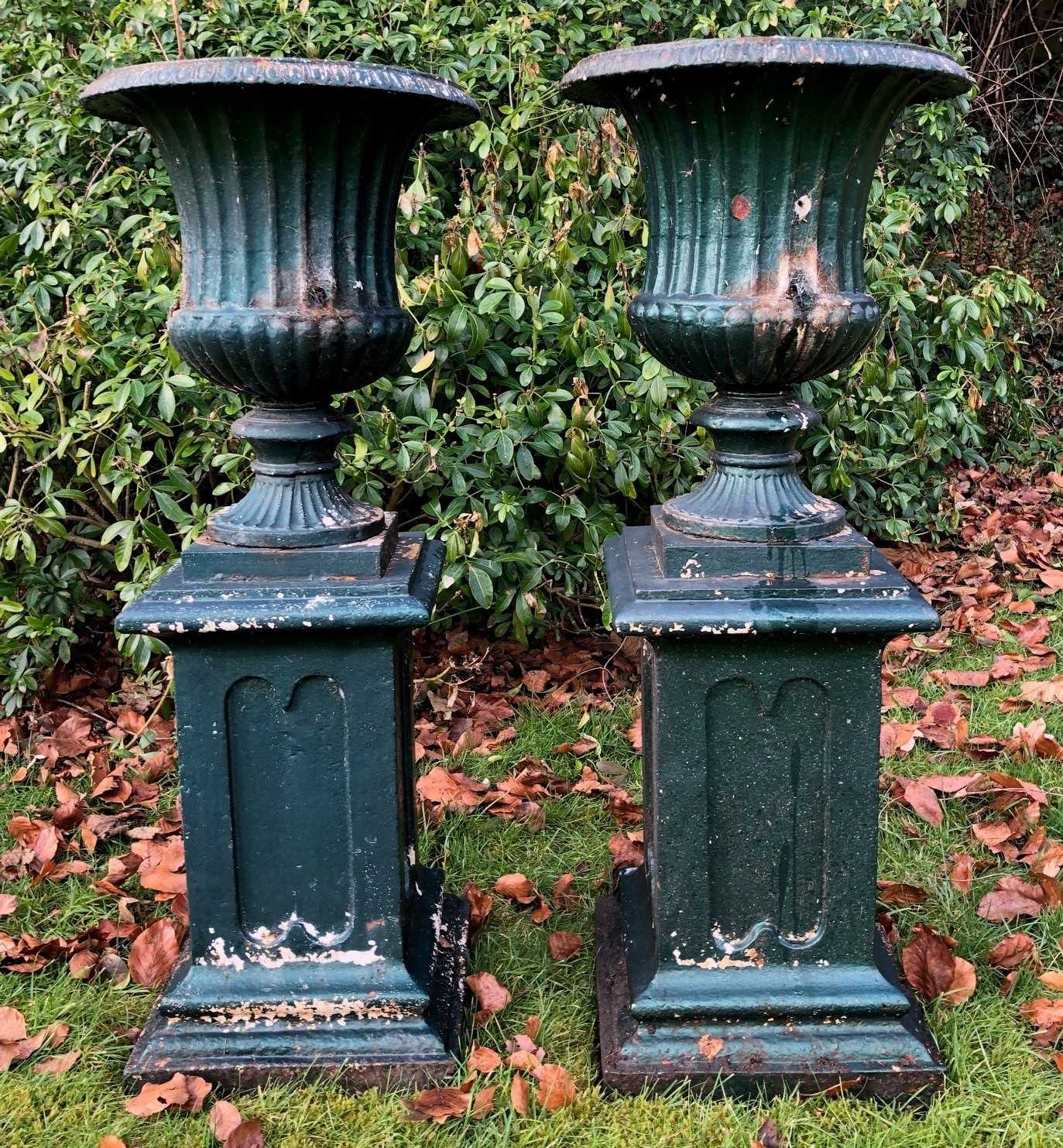 A pair of antique green painted cast iron campana urns