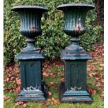A pair of antique green painted cast iron campana urns