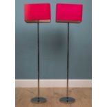 A pair of tall modern floor lamps with chrome stands and rectangular fuschia lampshades