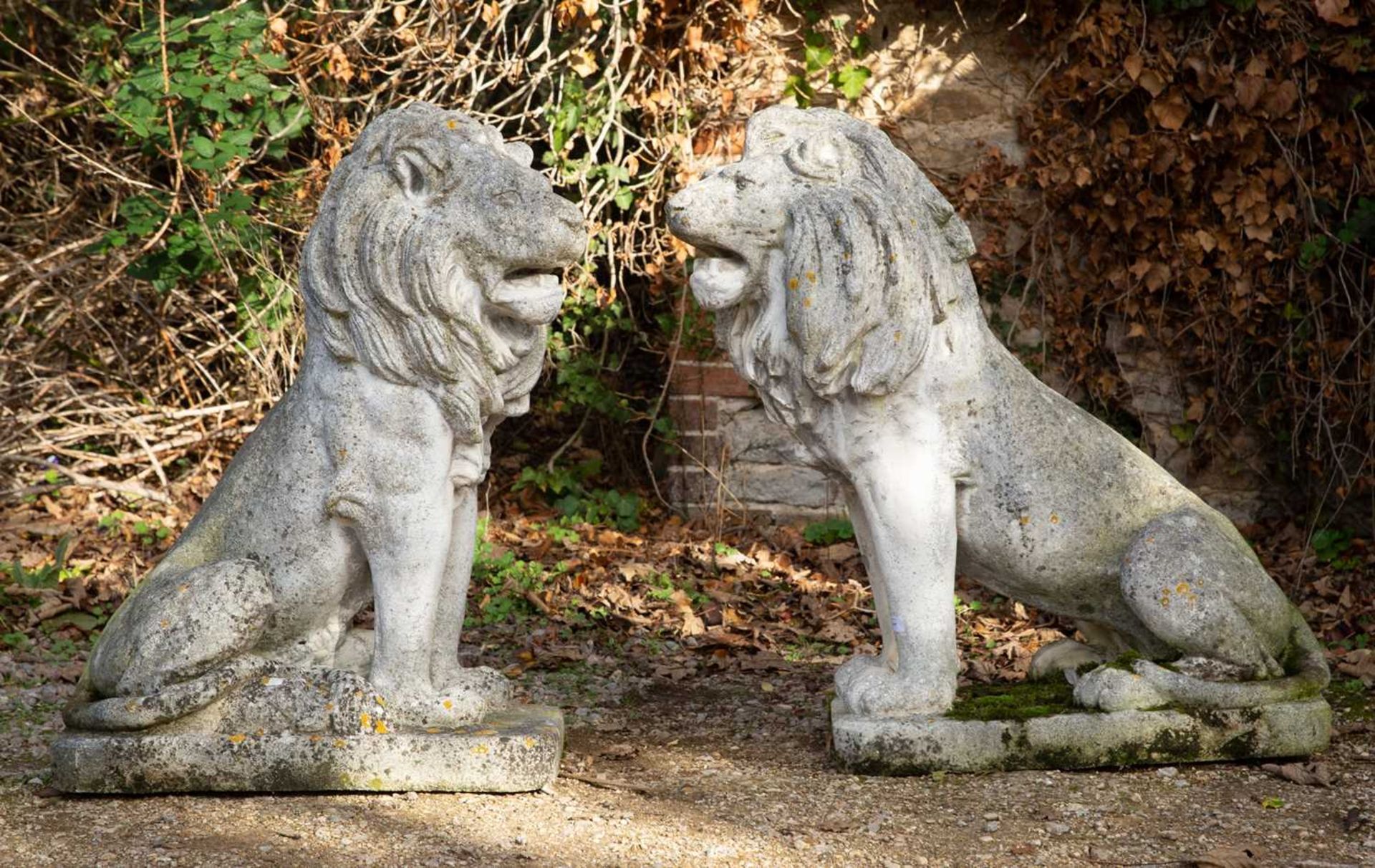 A pair of large cast reconstituted stone seated lions