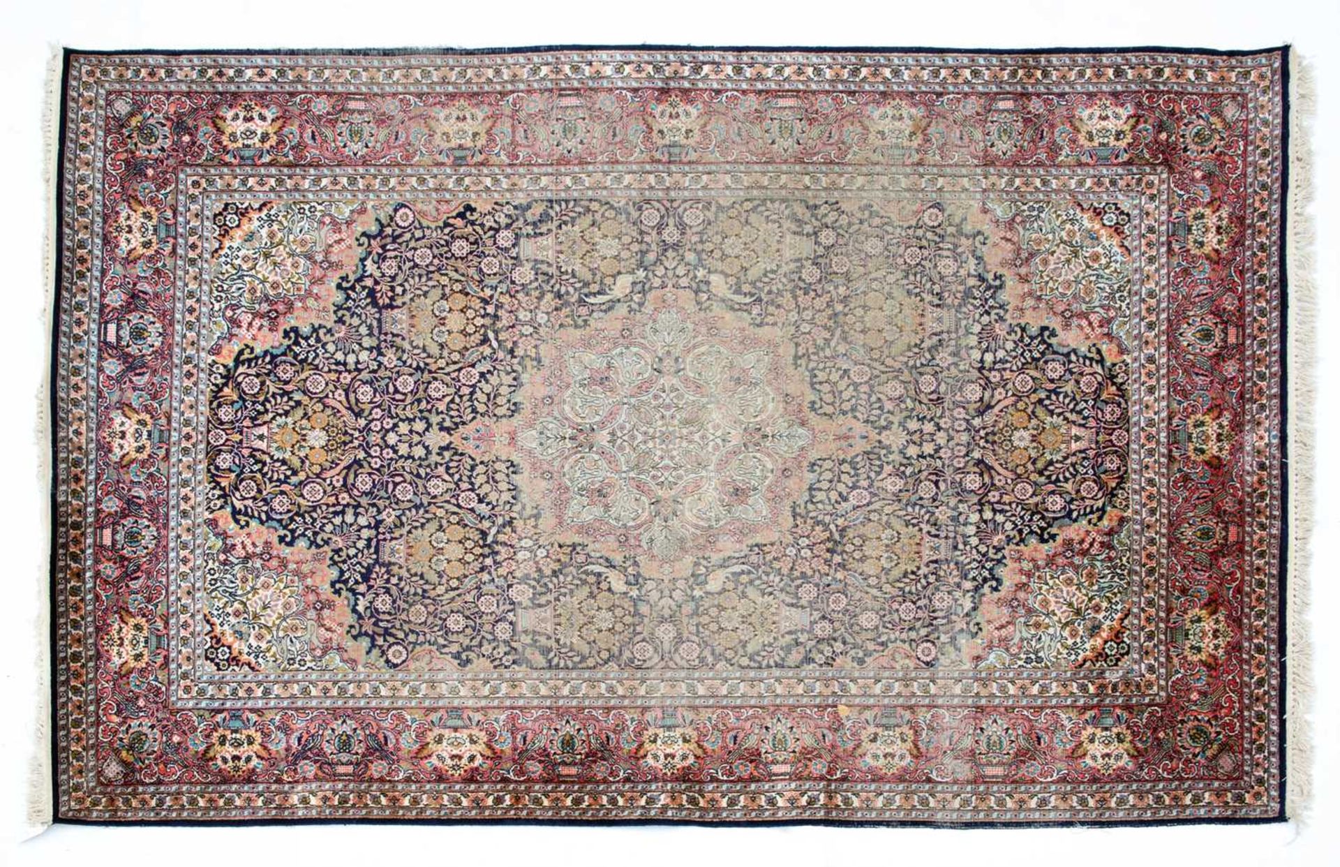 An Indian blue and red ground part silk rug