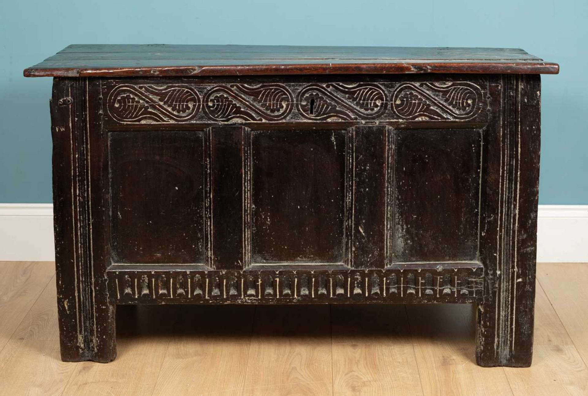 An antique coffer with a triple panel front