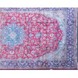 A large Oriental red ground rug with floral decoration within a blue banded border (490cm x 292cm)