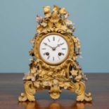 A 19th Century French ormolu mantle clock the decorative case mounted with porcelain flowers, the