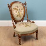 A low chair, with green needlework upholstery and a floral design, on carved wooden backrest and