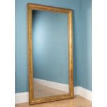 A large gilt and red painted framed wall mirror, with foliate design and wood panelling to the back.