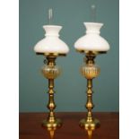 A pair of brass oil lamps with glass shades, each 48cm high (2)Used condition, one lamp has a broken