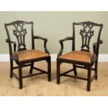A pair of chairs, mahogany, marked 'Warings London' to the underside, carved backrest detail and