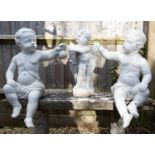 Three white composite stone cherub sculptures
