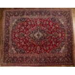 Ardekan red and blue ground wool carpet Iranian, with floral and foliate designs in and around a