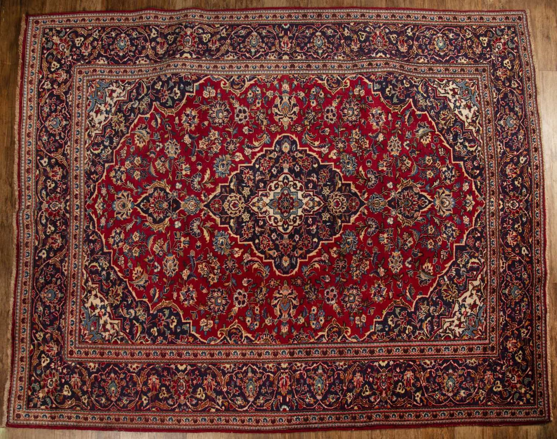 Ardekan red and blue ground wool carpet Iranian, with floral and foliate designs in and around a