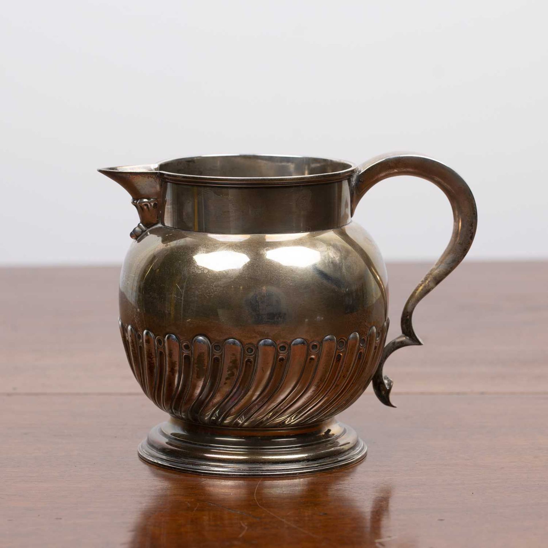 Victorian silver jug with trophy handle on circular base, bearing marks for Walter & John Barnard,