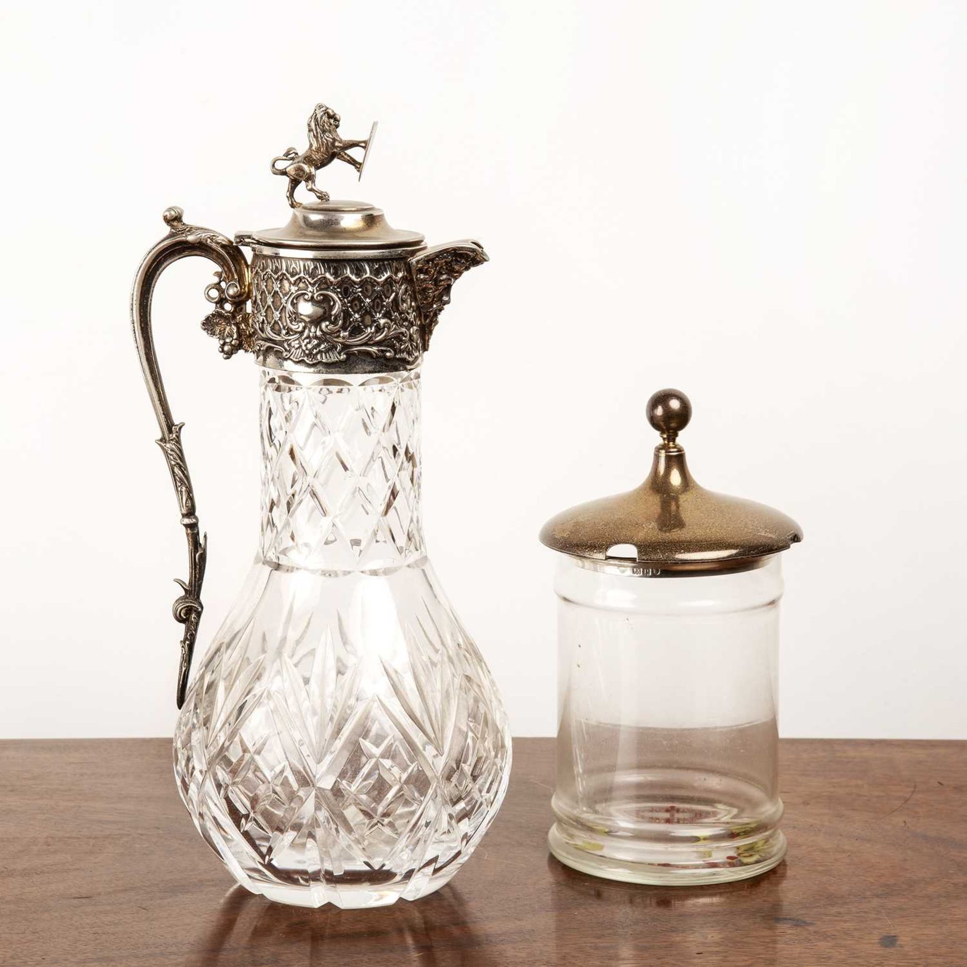 Heavy glass and silver plated claret jug with a lion finial, 30cm high and a silver lidded glass