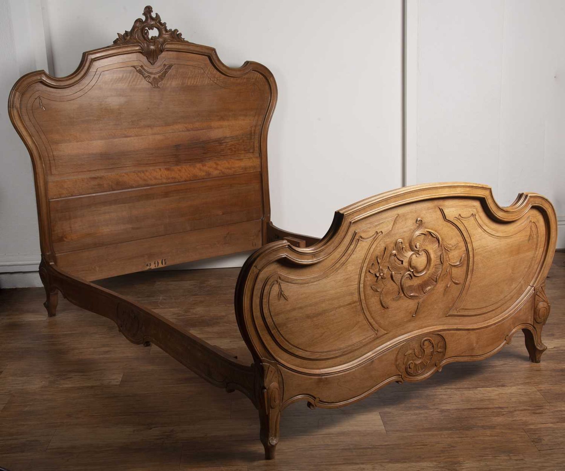 Walnut carved double bedstead French, late 19th Century, with carved cartouche and with two part