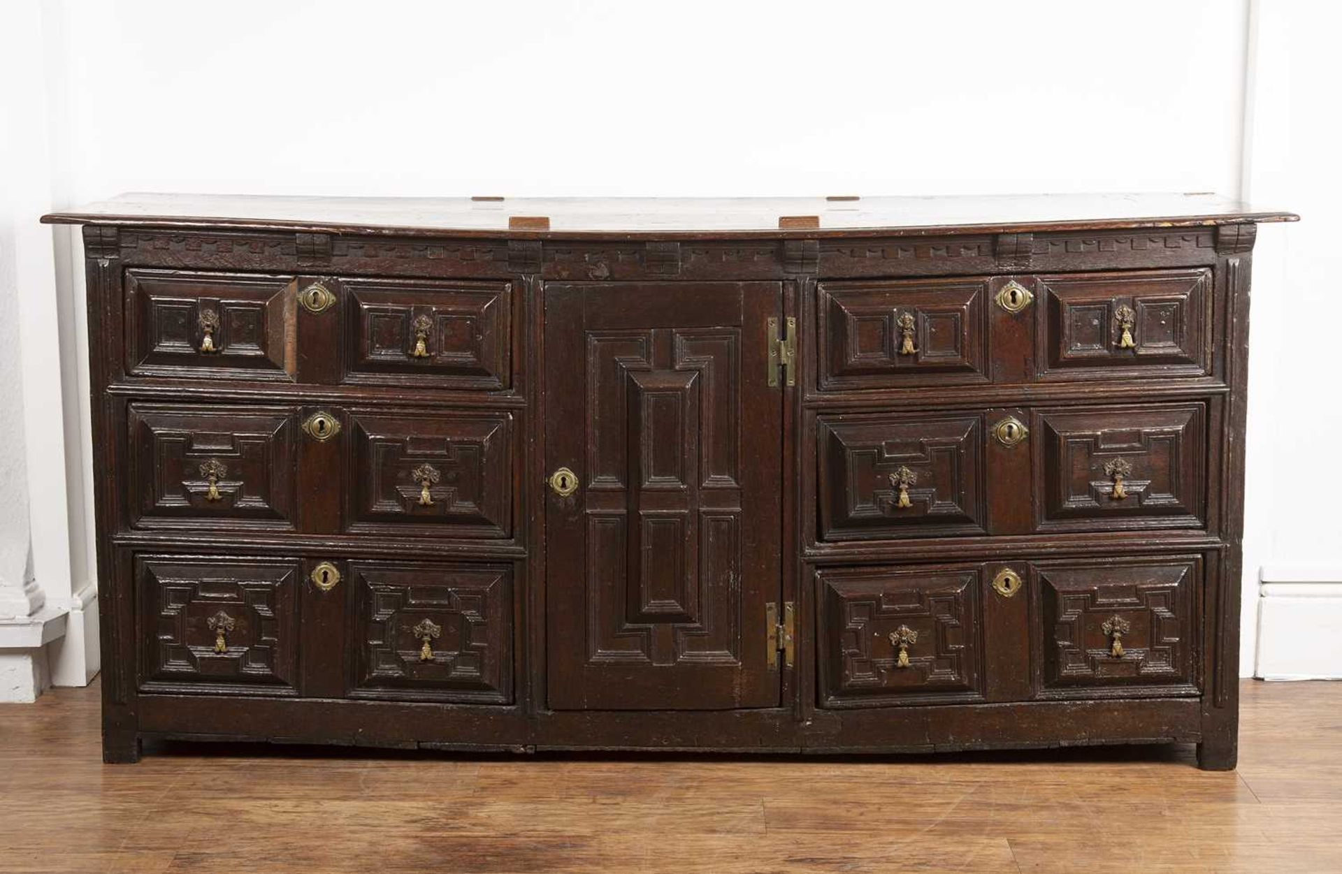 Moulded front dresser 17th/18th Century, fitted drawers and a central cupboard, with old brass