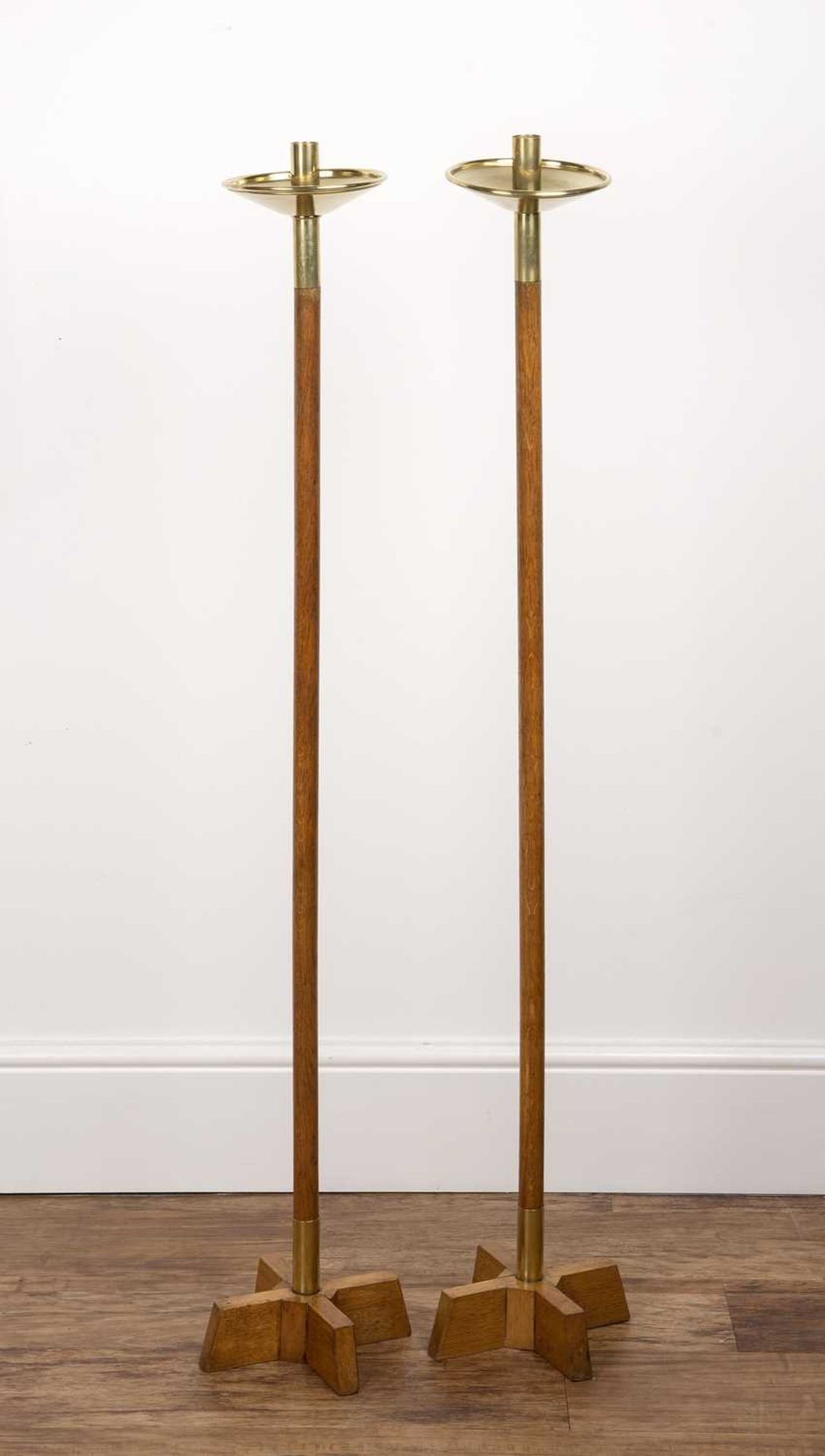 A pair of oak and brass tall floor standing candle stands in the Arts & Crafts style, 118cm high