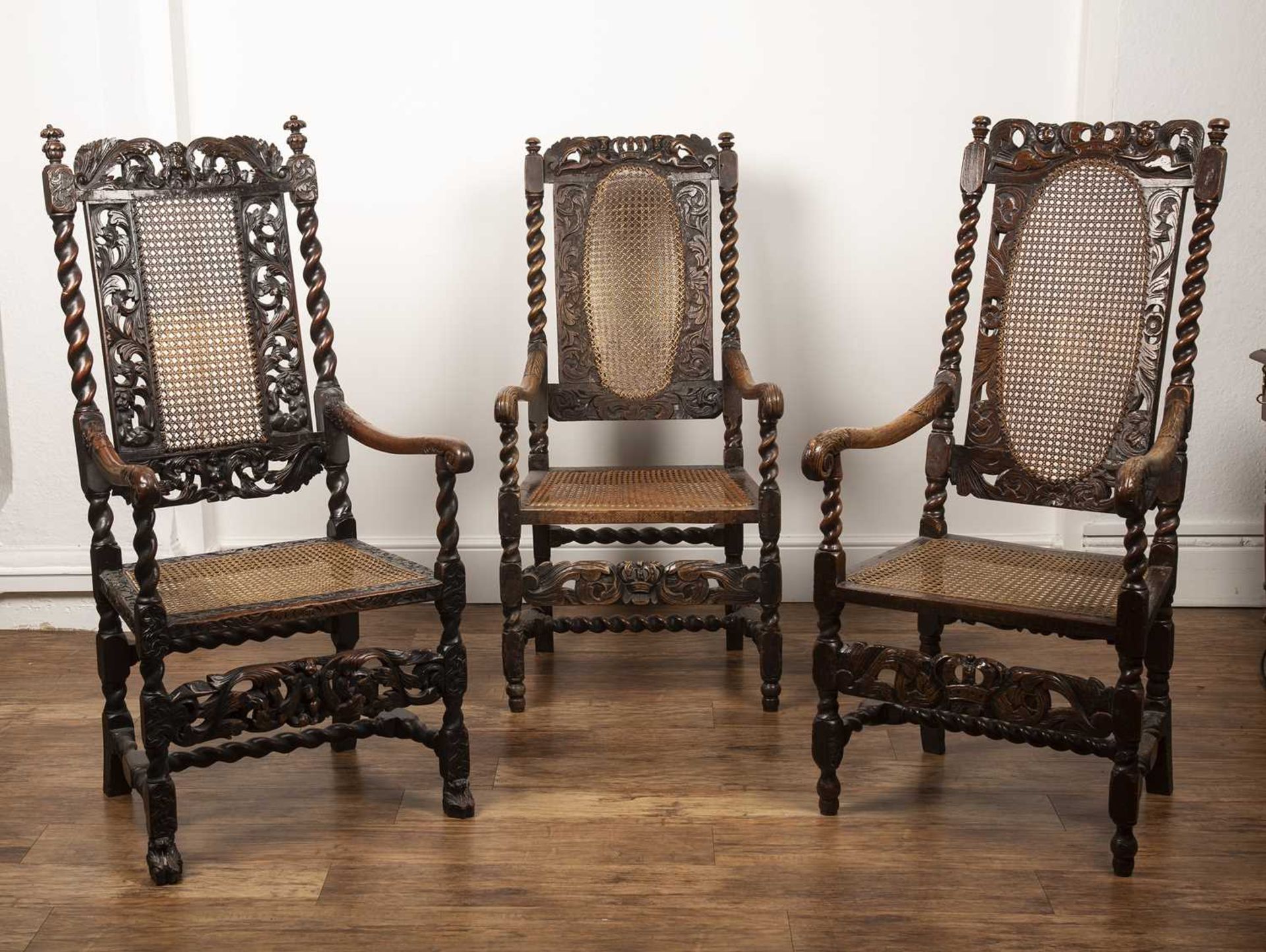 Three similar walnut armchairs Carolean and later, each with carved putti and coronet, and cane