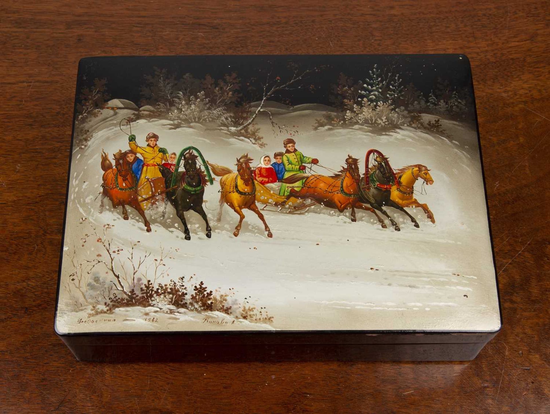 Russian lacquered box 20th Century, painted scene of figures in horse drawn troikas, signed and