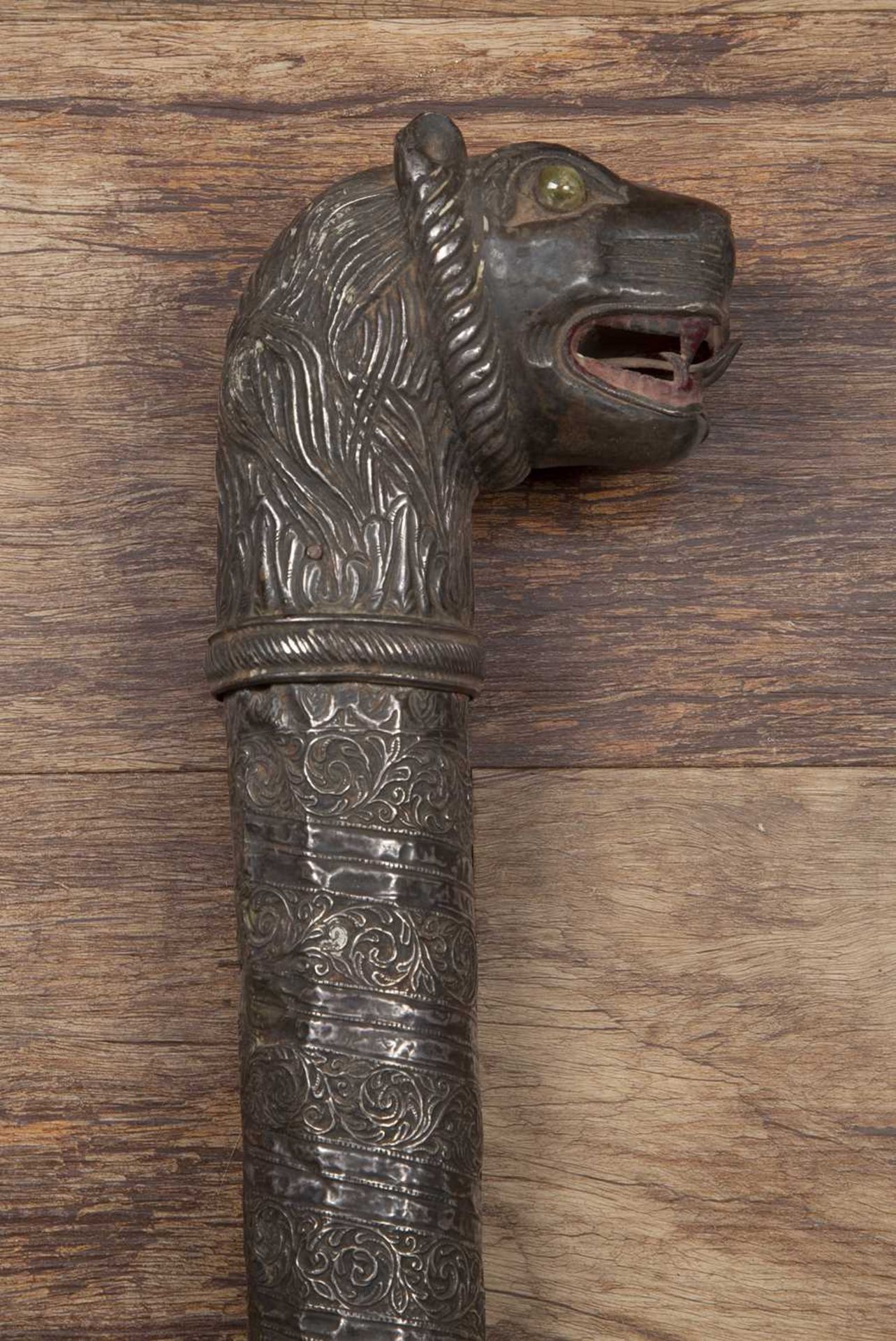 White metal coloured mace Iranian, with a lion's head handle, inlaid with green hardstone eyes, 72cm