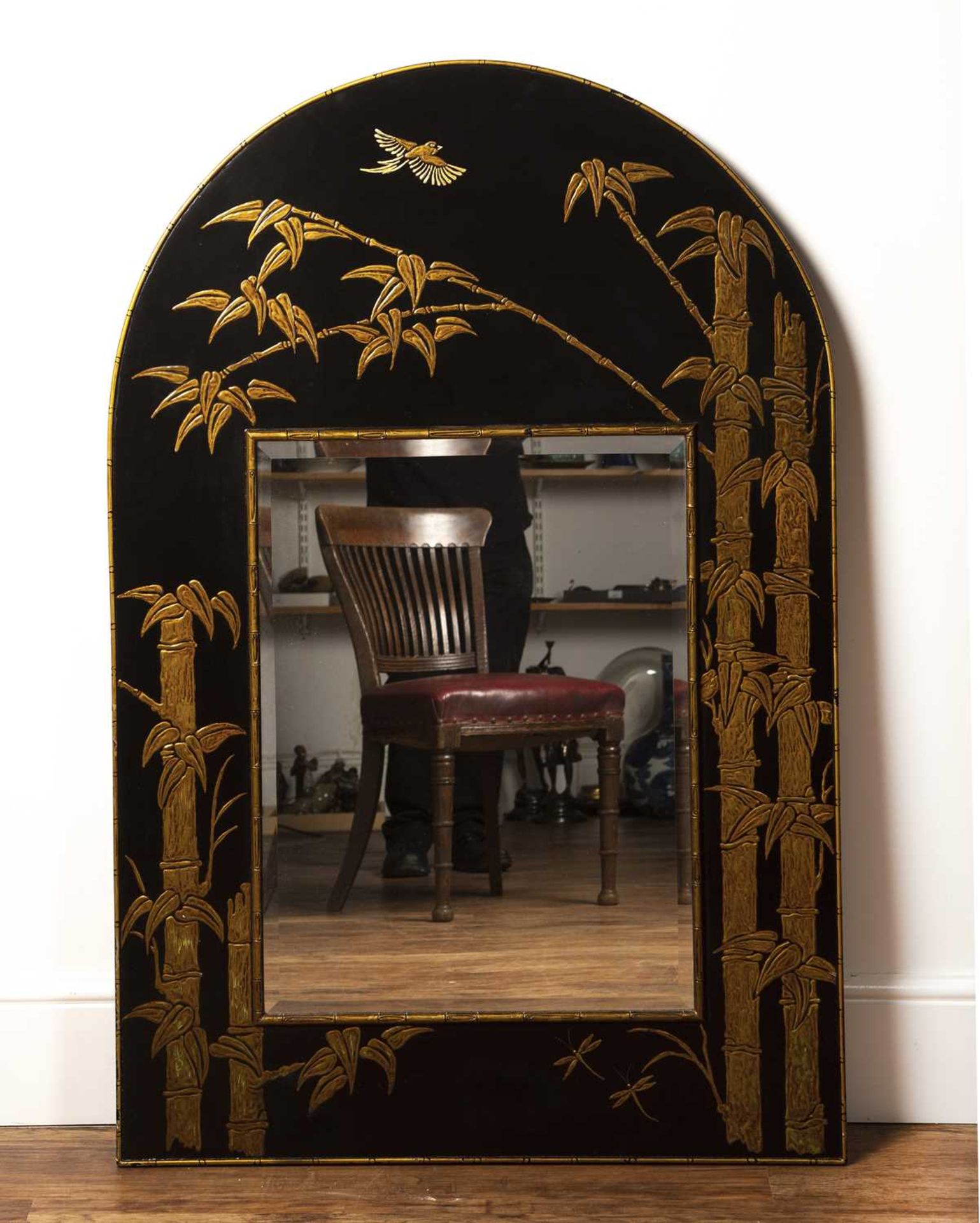 Black ground arched mirror 20th Century, in the Chinese manner, decorated with bamboos and birds,
