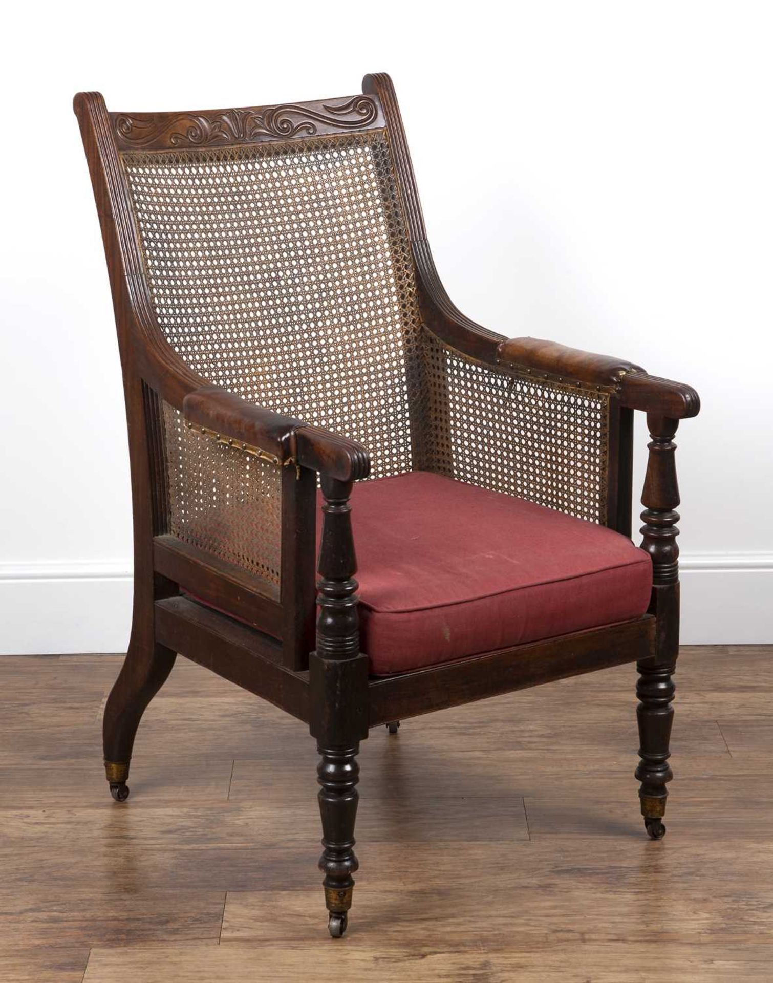 Mahogany Bergere library chair 19th Century, with leather and brass studded armrests with cane to