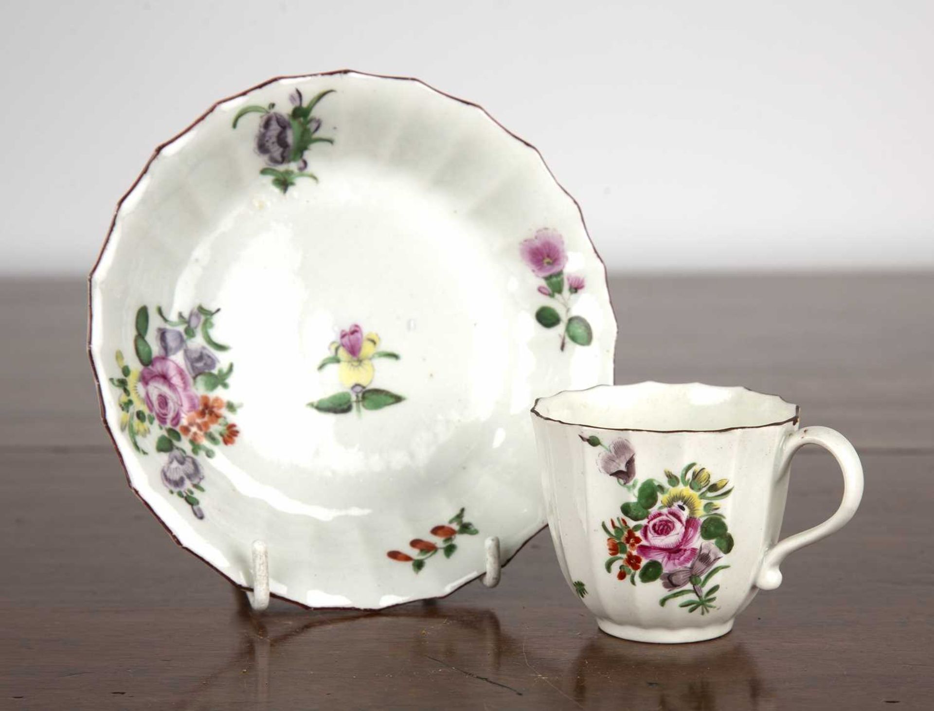 Worcester coffee cup and saucer circa 1770, of fluted form and painted with sprays of flowers,