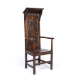 An antique oak high back panelled open armchair with carved decoration, 58cm wide x 51cm deep x 48cm