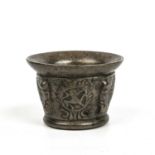 A 17th century bronze mortar having armorial decoration and a flared rim, 12.5cm diameter x 9cm in