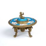 A 19th century French ormolu and porcelain ink well with a cherub finial, a blue ground and floral