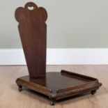 A hardwood low possibly library book trolley, the shaped splat with pierced handle, 45cm wide x 58cm