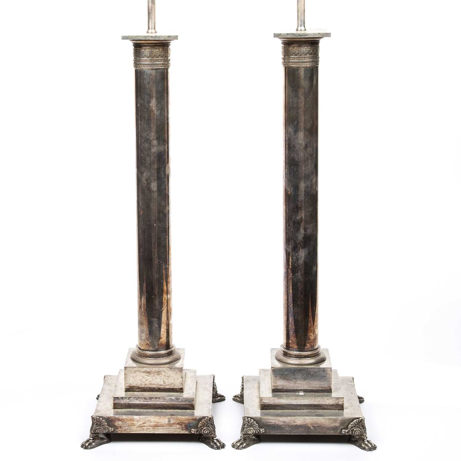 A large pair of silver plated table lamps of corinthian column form on stepped bases with paw