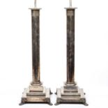 A large pair of silver plated table lamps of corinthian column form on stepped bases with paw